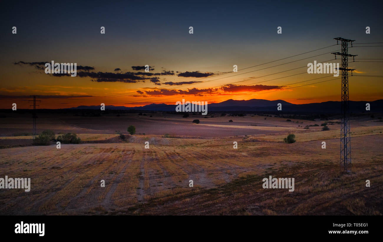 Tour de l'électricité haute tension dans le coucher du soleil dans la campagne Banque D'Images