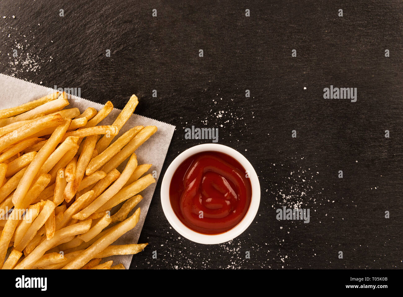 Les frites avec du ketchup sur fond sombre, directement au-dessus. Close up. Banque D'Images