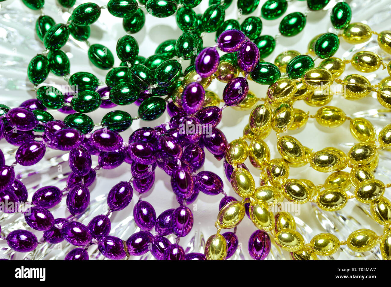 Mardi Gras couleur traditionnelle de trois colliers de perles sur un fond de  verre en cristal blanc Photo Stock - Alamy