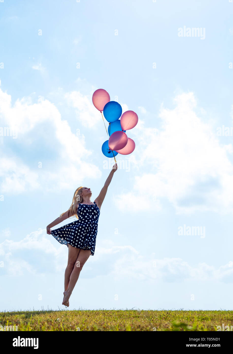 Female ballet dancer holding balloons flying loin Banque D'Images