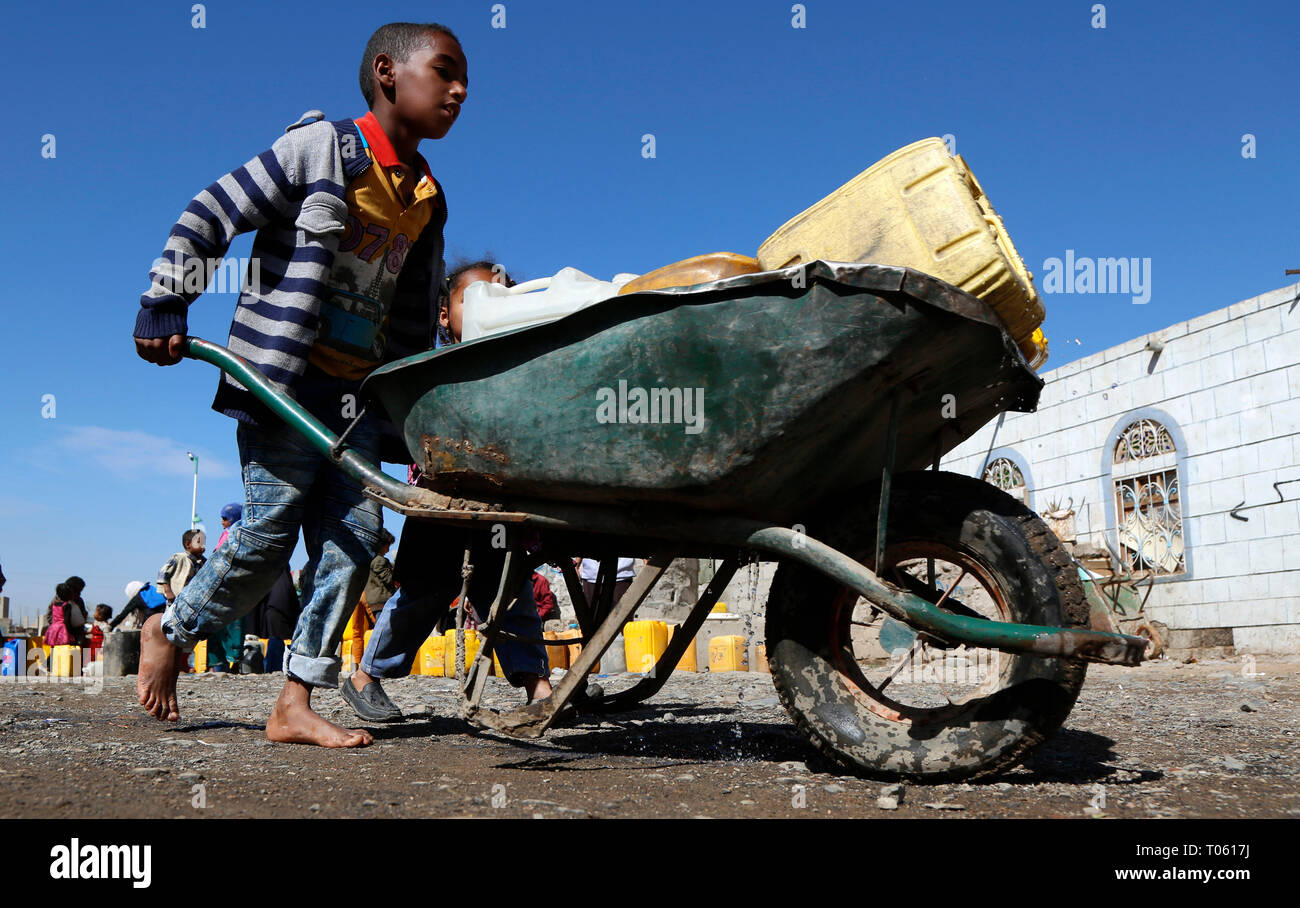 Sanaa, Yémen. Mar 17, 2019. Un garçon pousse une brouette transportant des bouteilles remplies avec de l'eau au cours d'une crise de l'eau propre, par crainte de choléra à Sanaa, Yémen, le 17 mars 2019. Au moins 12 personnes sont mortes à la suite d'une épidémie de choléra qui a fait plus de 4 000 autres personnes infectées au Yémen cette année, Mathar Abbas, Mirwani la tête de la santé local Ministère de Sanaa, a déclaré vendredi. Credit : Mohammed Mohammed/Xinhua/Alamy Live News Banque D'Images