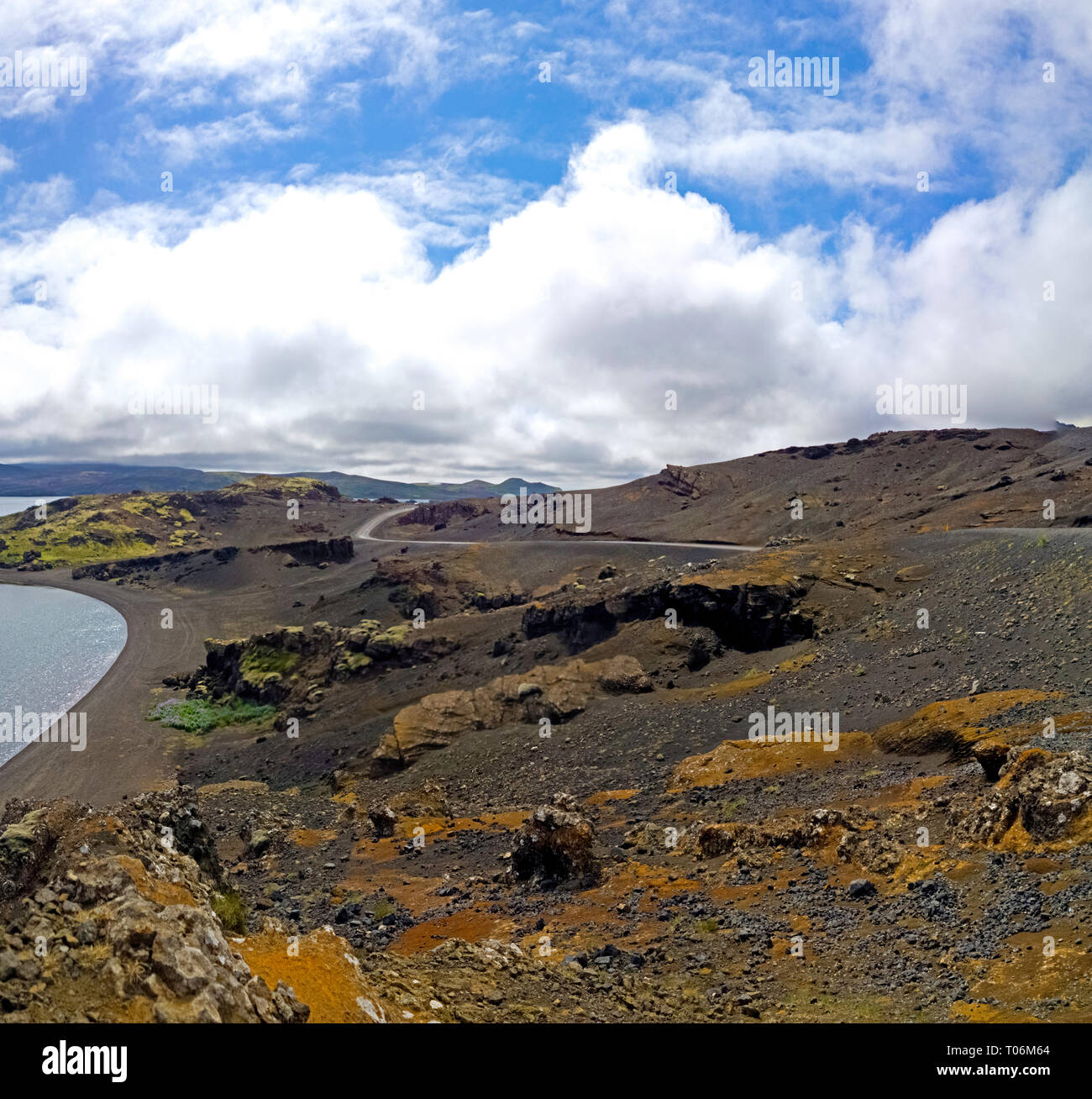 Un lac intérieur et le littoral des routes dans le paysage volcanique du centre de l'Islande. Un robuste stérile lake shore est remplie de roches volcaniques. Banque D'Images