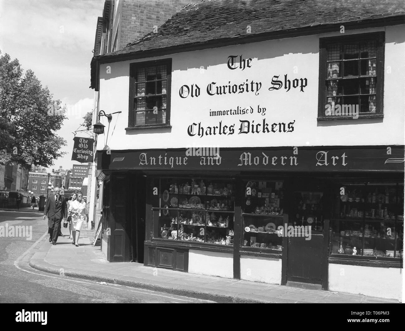 Années 1960, extérieur d'un bâtiment de ville aux poutres apparentes du XVIe siècle qui aurait inspiré le célèbre roman de 1841 de l'écrivain anglais Charles Dickens, « The Old Curiosity Shop », Londres, Angleterre, Royaume-Uni. L'un des plus anciens magasins de Londres, le nom du magasin, l'Old Curiosity Shop, a été ajouté après la parution du roman. La boutique avec des sols en pente a survécu non seulement au Grand incendie de Londres mais aussi au Blitz de la seconde Guerre mondiale. Dans cette époque, un magasin vendant des antiquités, il a commencé la vie comme une laiterie, rumeur d'avoir été donné comme présent par le roi Charles II à l'une de ses nombreuses amies. Banque D'Images