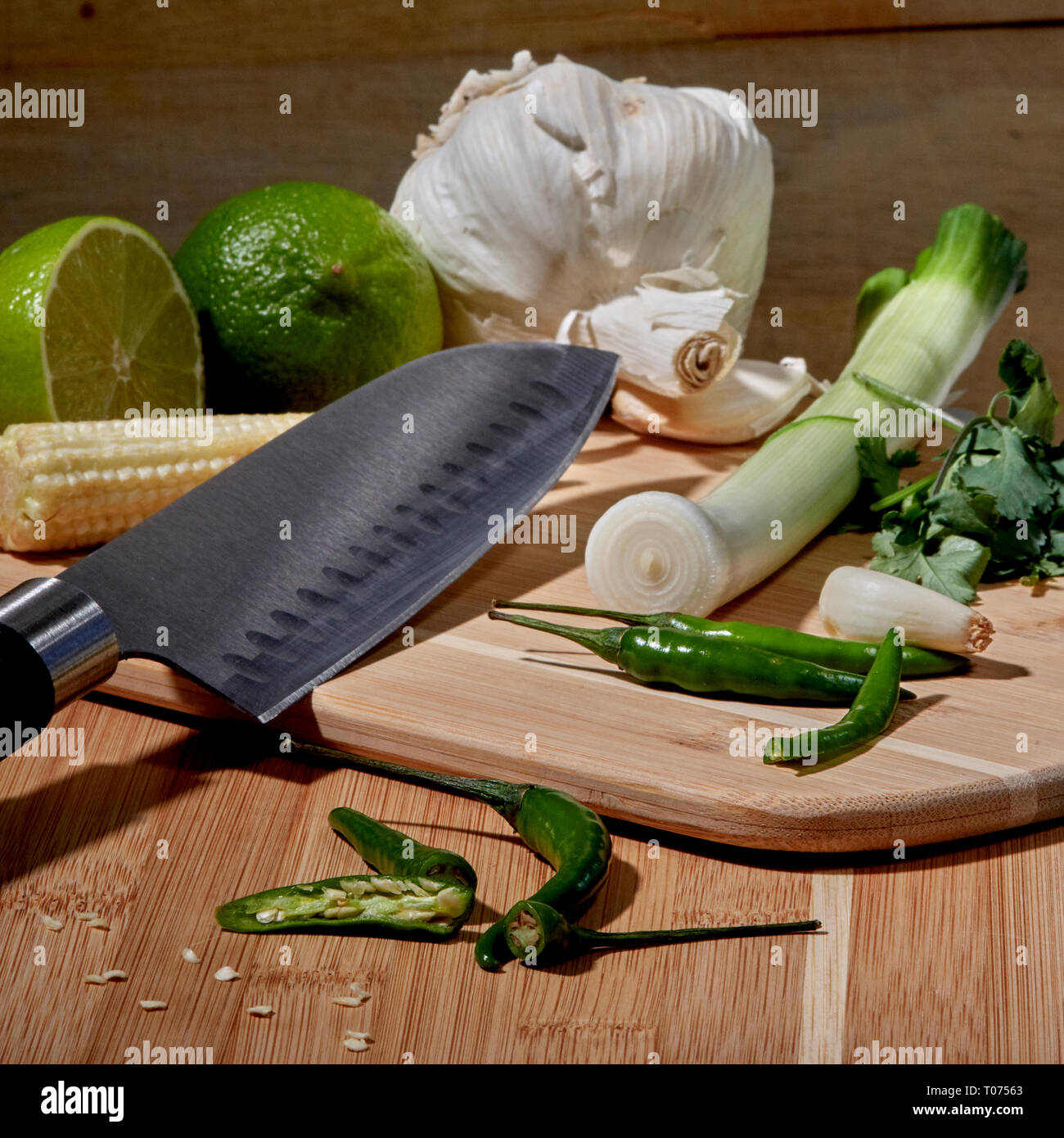 Piments Thaï asiatique et les légumes les ingrédients sur planche à découper avec Couteau Santoku Banque D'Images