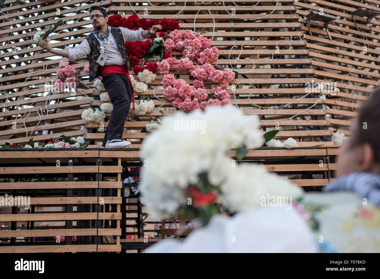 Les hommes habillés en costume traditionnel, à la base de travail d'un grand modèle de la Virgen de los Desamparados (La Vierge des Réprouvés) couvrant de fleurs pendant Fallas de Valence. Les Fallas sont immenses sculptures représentant des personnages célèbres ou des événements actuels dans les rues de Valence qui peut être vu au cours de la 'Las Fallas' Festival, les sculptures seront ensuite graver le 19 mars 2019 en hommage à Saint Joseph, saint patron de la guilde des charpentiers. Banque D'Images