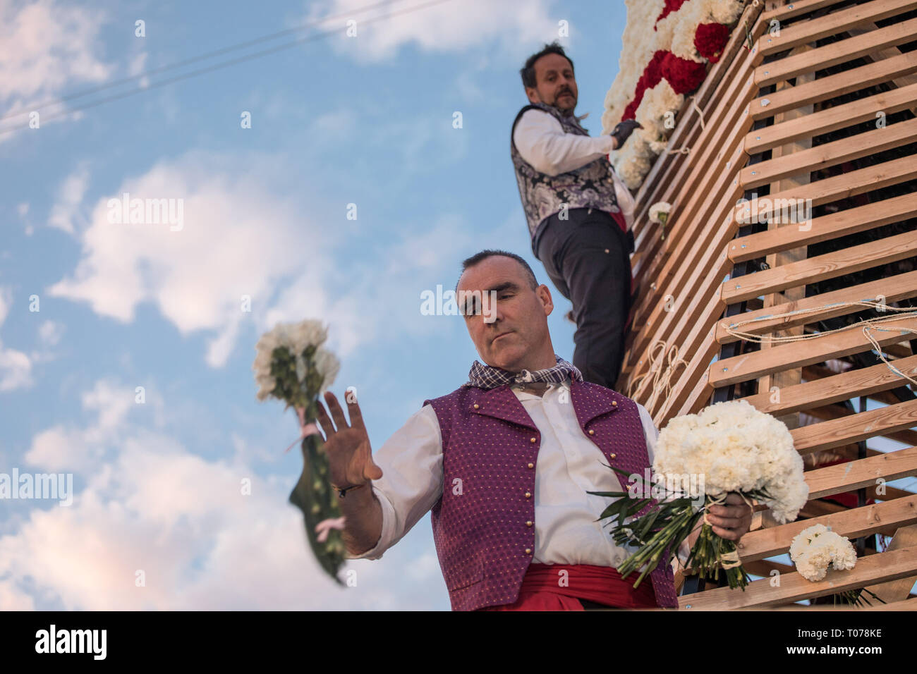Les hommes habillés en costume traditionnel, travail sur grand modèle de Virgen de los Desamparados (La Vierge des Réprouvés) couvrant de fleurs pendant Fallas de Valence. Les Fallas sont immenses sculptures représentant des personnages célèbres ou des événements actuels dans les rues de Valence qui peut être vu au cours de la 'Las Fallas' Festival, les sculptures seront ensuite graver le 19 mars 2019 en hommage à Saint Joseph, saint patron de la guilde des charpentiers. Banque D'Images