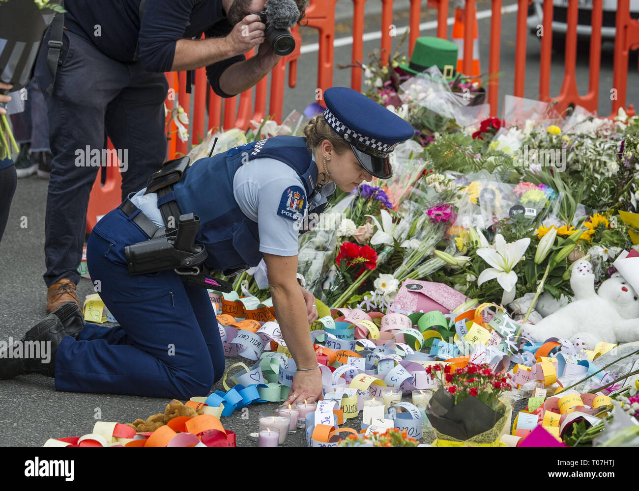 Christchurch, Canterbury, Nouvelle-Zélande. 18 Mar, 2019. Un agent de police permet d'organiser des hommages à la suite d'une '"élèves" l'Union dans l'amour'' veillée de Hagley Park, près de la mosquée Al Noor, où 41 personnes ont été tuées. Des milliers d'élèves des écoles locales ont assisté à la veillée, organisée par les élèves du secondaire en cachemire, où plusieurs élèves actuels et anciens ont été tués ou blessés dans la ville de deux prises de vue de la mosquée, qui a fait au moins 50 morts. Credit : PJ Heller/ZUMA/Alamy Fil Live News Banque D'Images