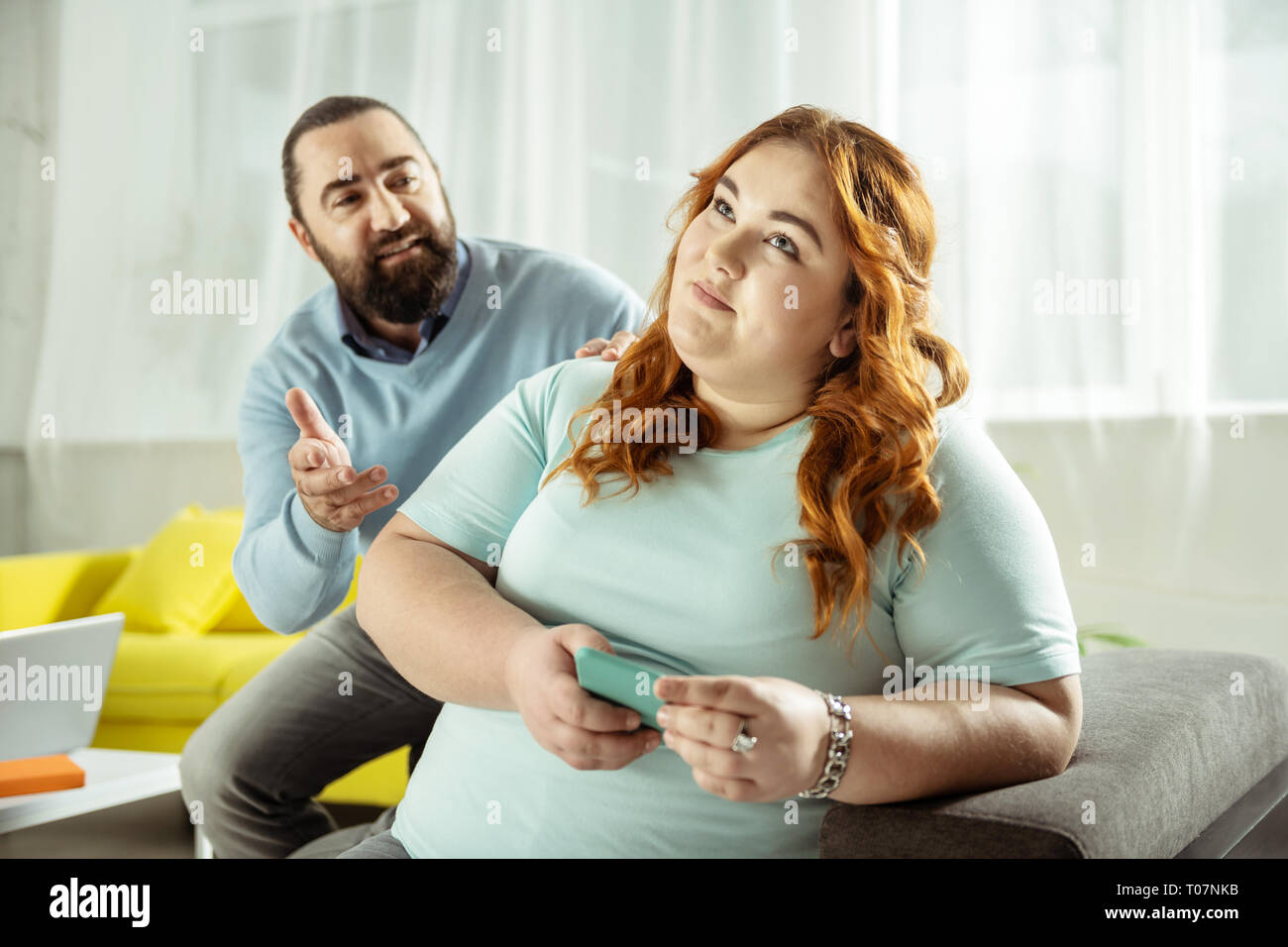 Femme aux cheveux bouclés de rêve à l'écoute de son interlocuteur Banque D'Images
