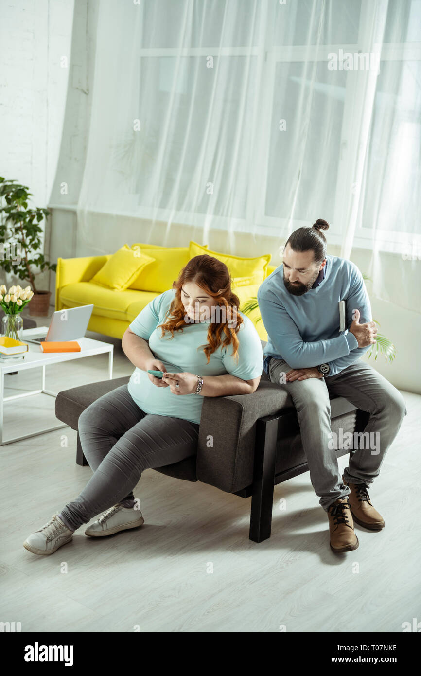 Surpoids concentré personne de sexe féminin à l'aide de son smartphone Banque D'Images