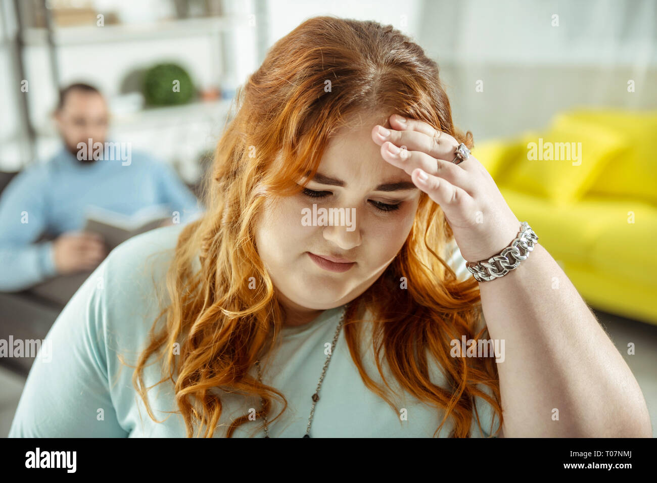 Red-haired woman inquiet debout sur l'avant-plan Banque D'Images
