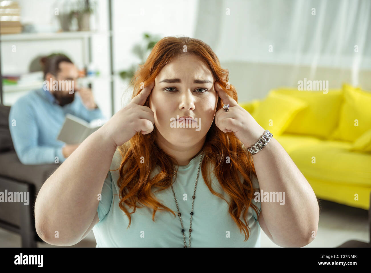 Attentifs aux cheveux rouge femme looking at camera Banque D'Images