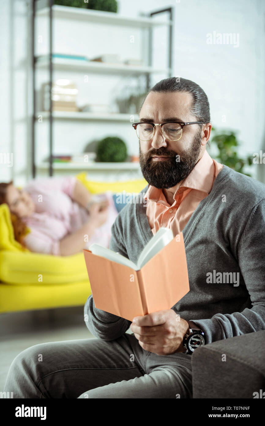 Thérapeute élégant attentionné assis sur l'avant-plan Banque D'Images