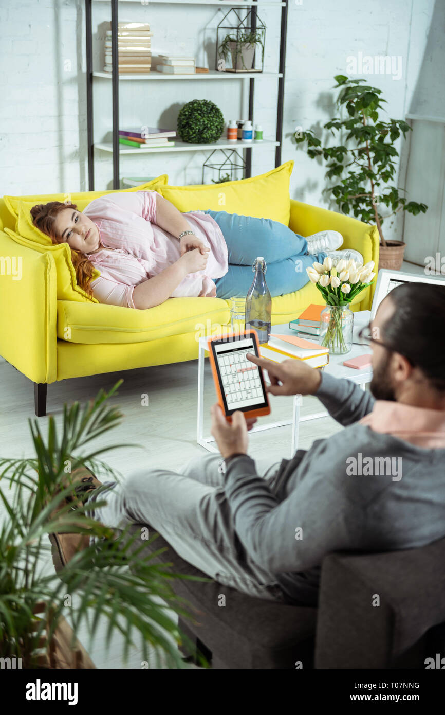 Fatigué joufflu femme lying on sofa Banque D'Images
