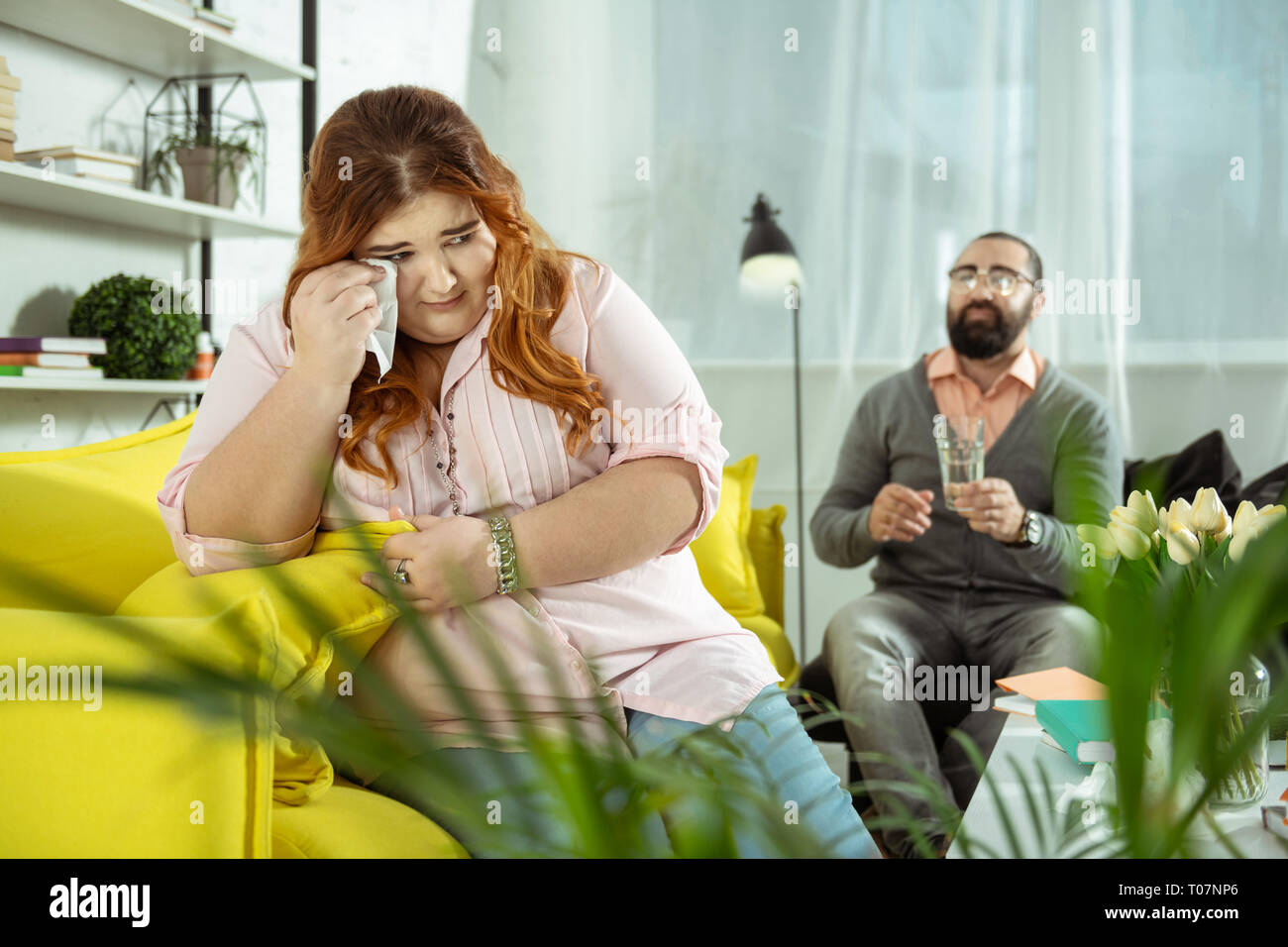 Bouleversé femelle rousse personne essuyant ses larmes Banque D'Images