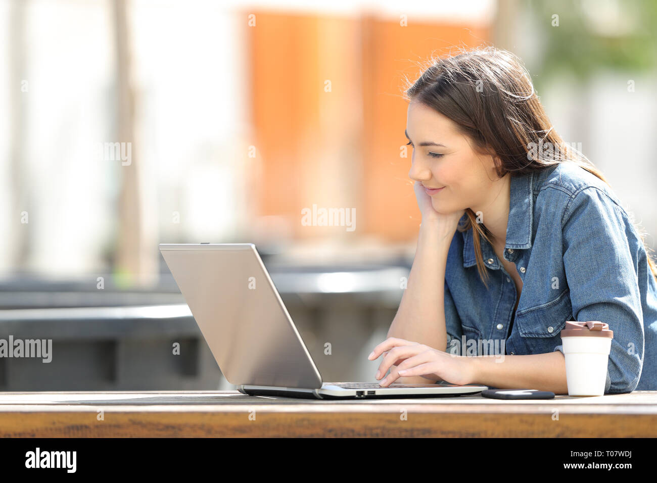 Femme sérieuse de regarder du contenu multimédia en ligne sur laptop sitting in a park Banque D'Images