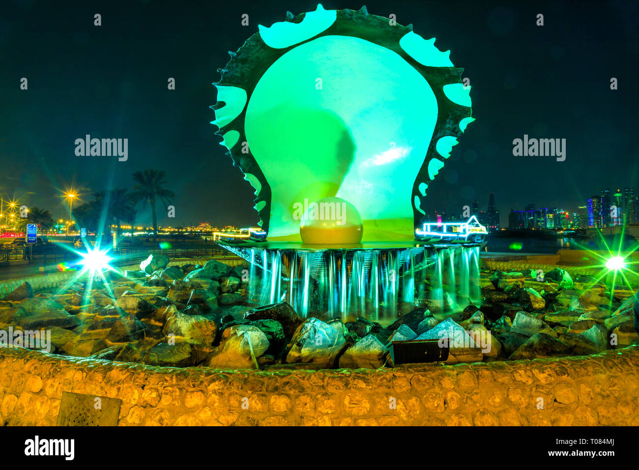 Doha, Qatar - Février 23, 2019 : l'huître perlière et emblématique Monument avec fontaine sur la Corniche, la promenade au début de l'Harbour Dhow allumé Banque D'Images