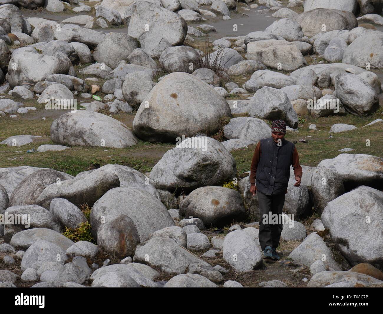 MANALI, HIMACHAL PRADESH, INDE--MARS 2018: Un homme se tient sur les rochers de la rivière Beas à Manali. Banque D'Images