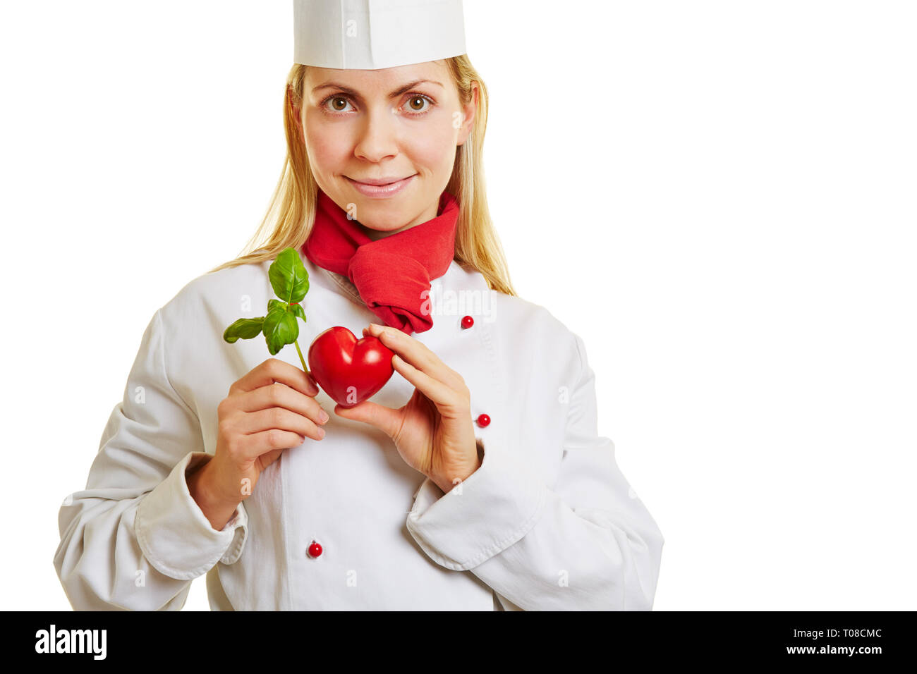 Jeune Cuisinier est titulaire d'un cœur rouge et vert basilic Banque D'Images