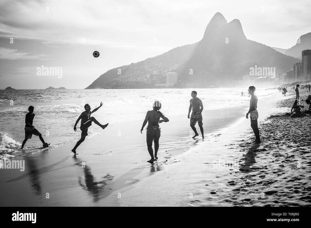 RIO DE JANEIRO, Brésil - 24 février 2015 : un groupe de Brésiliens jouant sur le rivage de la plage d'Ipanema, avec la célèbre montagne Dois Irmãos derrière eux Banque D'Images