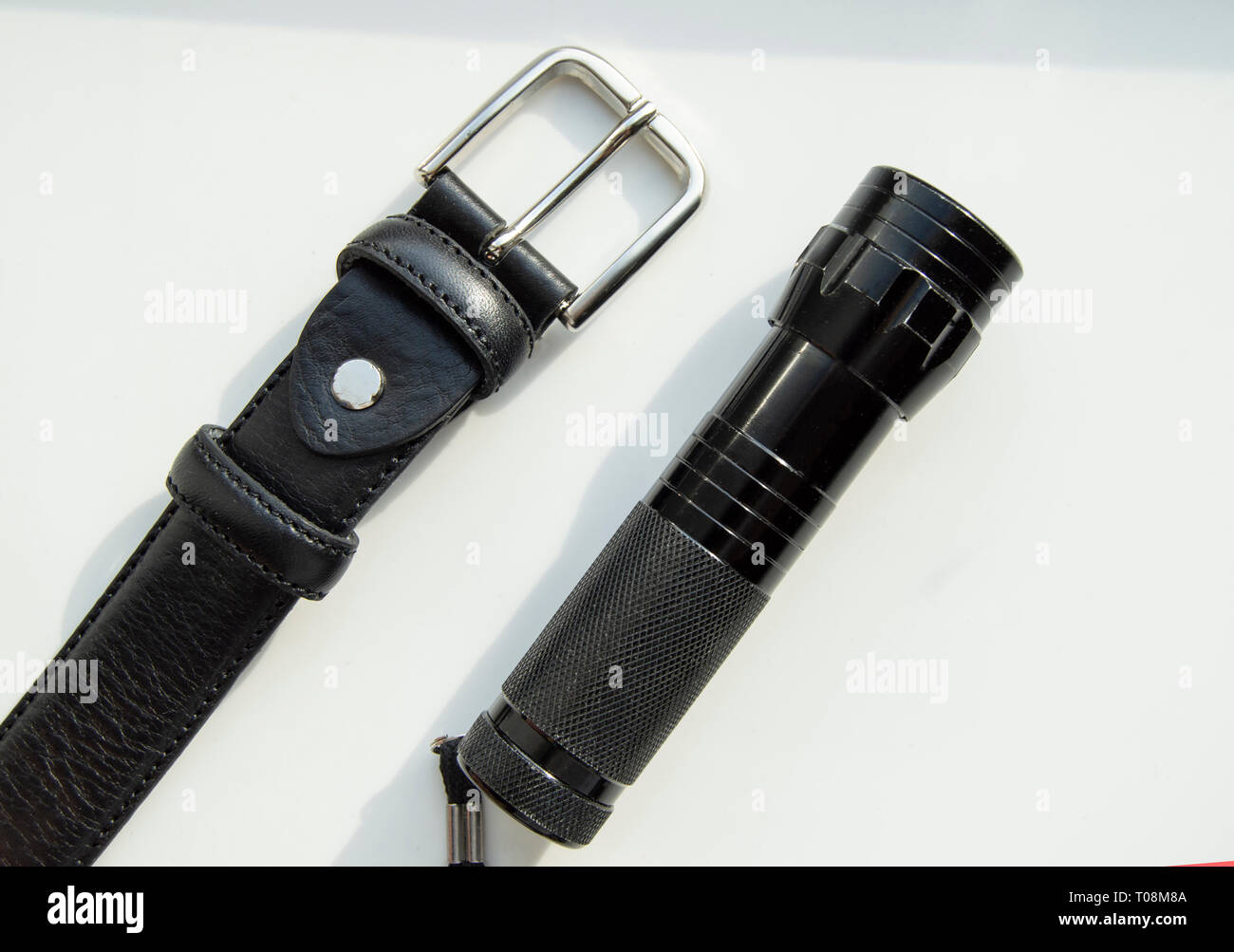 Accessoires pour hommes bracelet en cuir noir et lampe isolé sur fond blanc. Banque D'Images