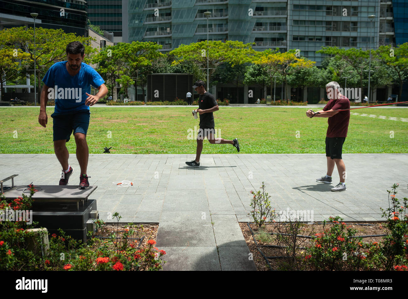 18.04.2018, Singapore, Singapour, Singapour - Deux hommes garder la forme durant leur pause déjeuner dans le quartier des affaires avec le circuit de la formation, alors qu'un jogger Banque D'Images