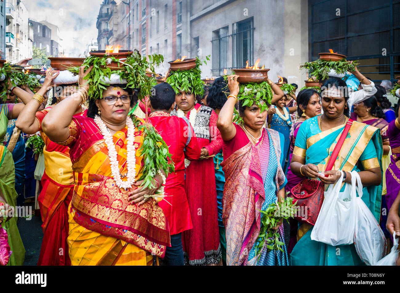 Sur Ganesh Chaturthi festival à Paris, danseuses portant des saris colorés, transporter sur leurs têtes des pots en terre cuite avec brûler du camphre. Banque D'Images