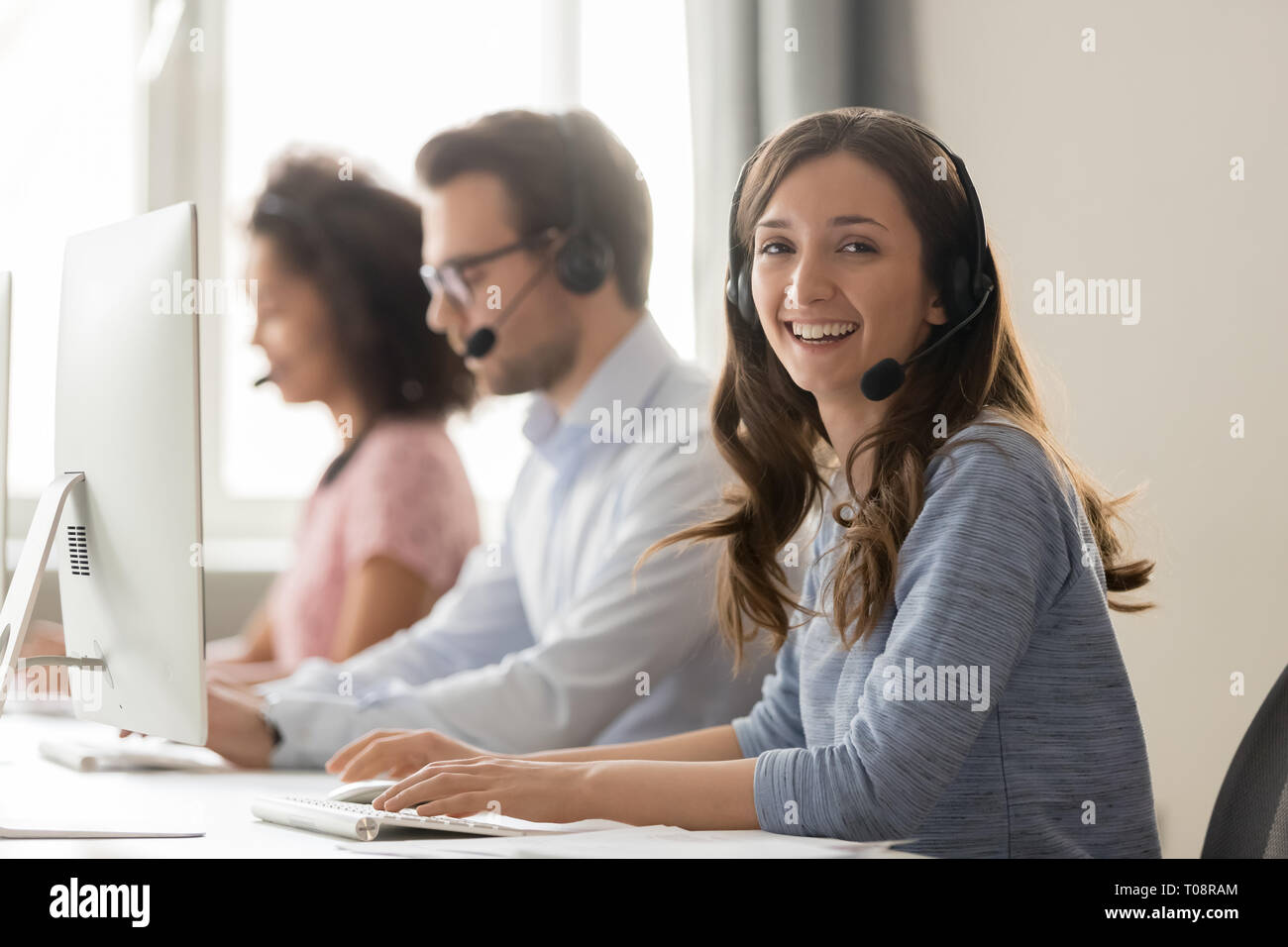 Agent de centre d'appel Happy businesswoman looking at camera sur le lieu de travail Banque D'Images