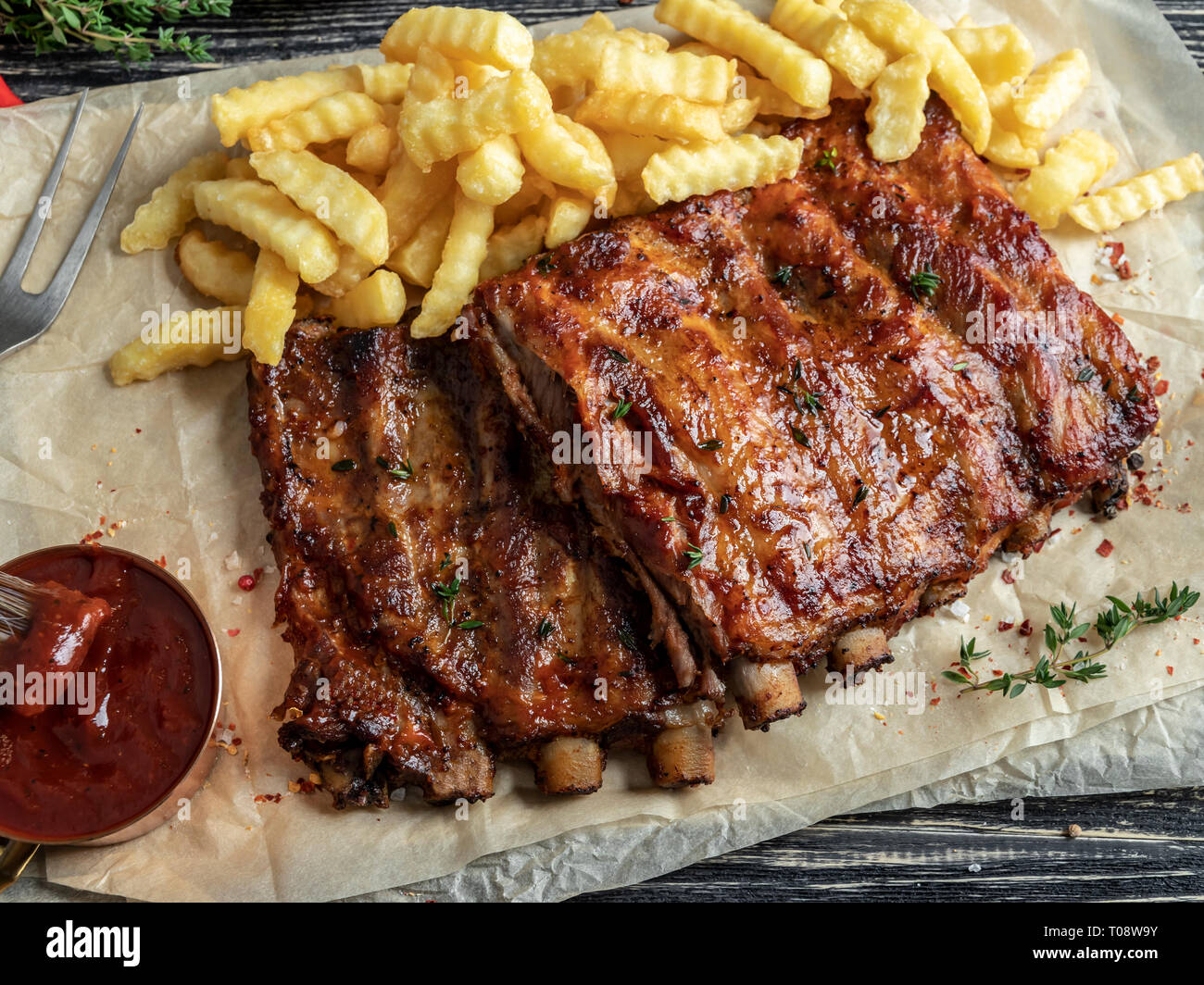 Côtes de porc grillées avec sauce , frites, d'épices, fond de bois Banque D'Images