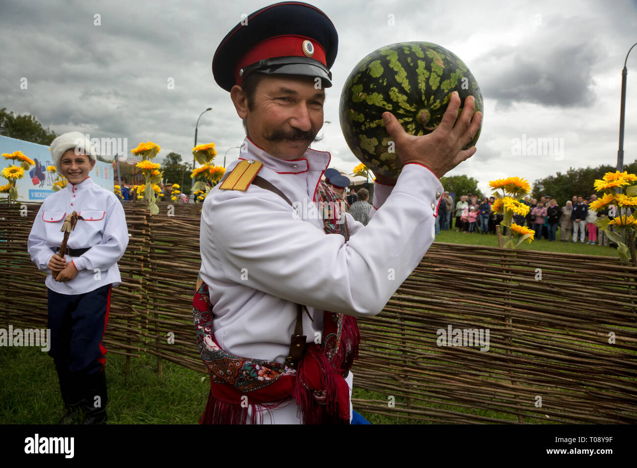 Participant du cinquième festival international 'village cosaque Moscow' dans le parc Kolomenskoye vient avec une pastèque sur la scène du festival Banque D'Images