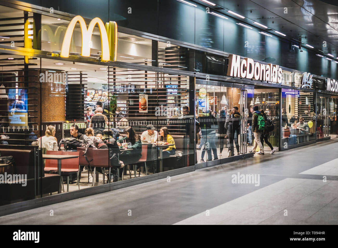 Berlin, Allemagne - mars 2019 : Les gens de manger au McDonalds / McCafe restaurant à l'intérieur de train stration (Berlin Hauptbahnhof) Banque D'Images