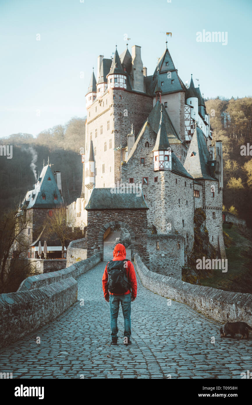Vue panoramique de young explorer avec sac à dos en admirant la vue au célèbre château d'Eltz au lever du soleil à l'automne, Rheinland-Pfalz, Allemagne Banque D'Images