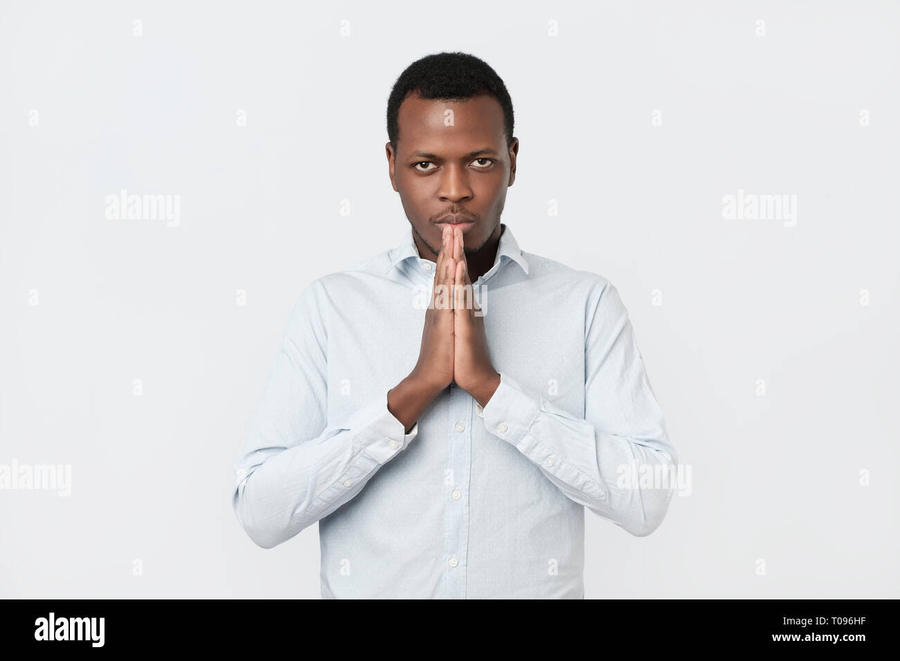 Inquiets young african american man mettre les mains ensemble demander de l'aide du pardon dans la prière Banque D'Images