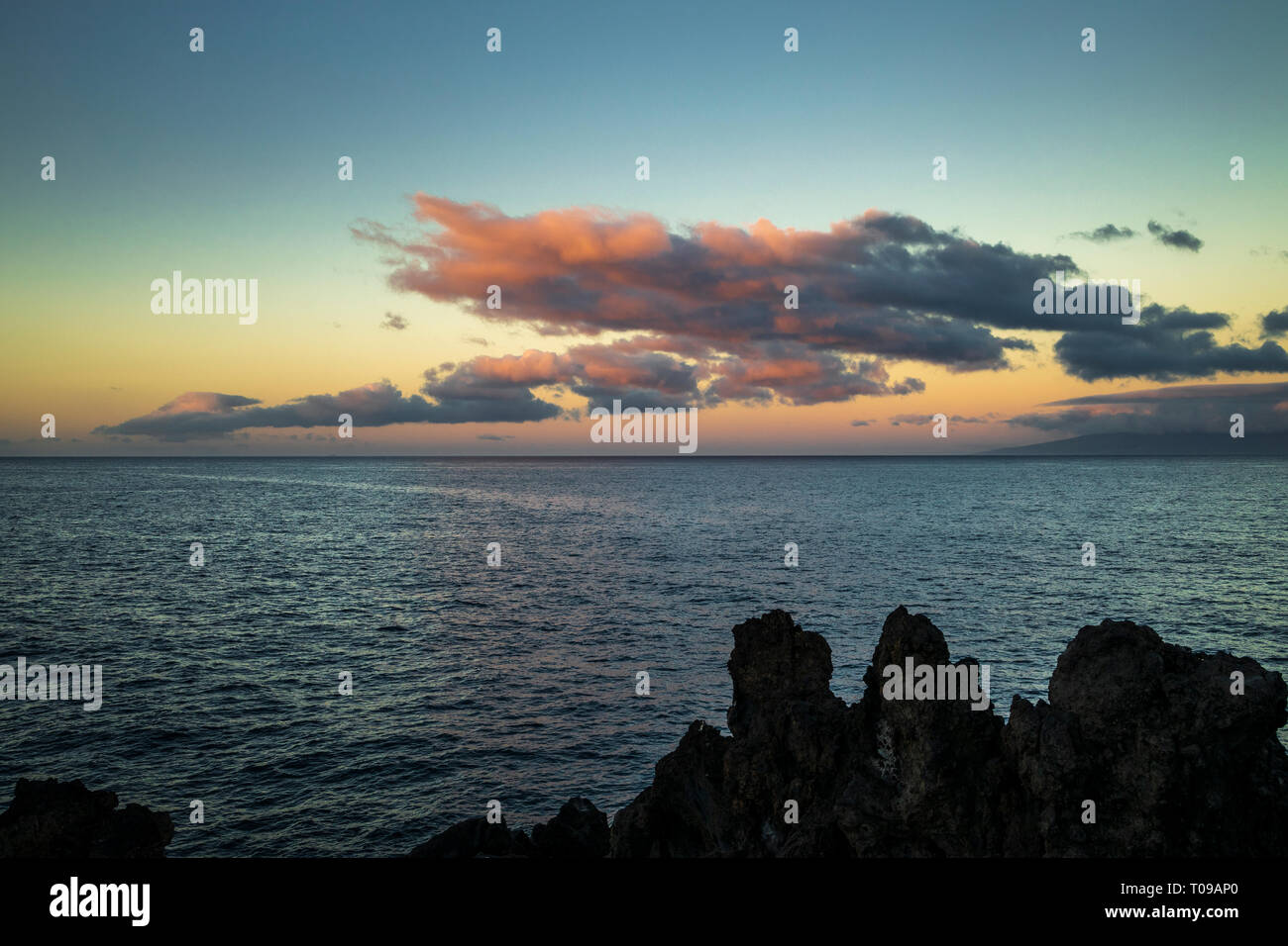 Les nuages au-dessus de l'Atlantique rouge par le lever du soleil avec l'île de La Gomera à l'horizon, à l'ouest de Playa San Juan avec la roche volcanique forma Banque D'Images