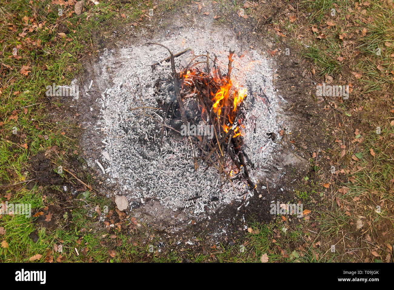 La mort des braises et cendres grises d'une branche de feu qui avait été allumé pour brûler les feuilles, brindilles, déchets de jardin, dans un jardin à la campagne. (104) Banque D'Images
