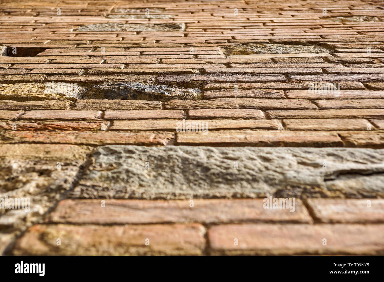 Un mur de pierre d'un bâtiment à partir du sol jusqu'à la prespective de mur en brique. Banque D'Images