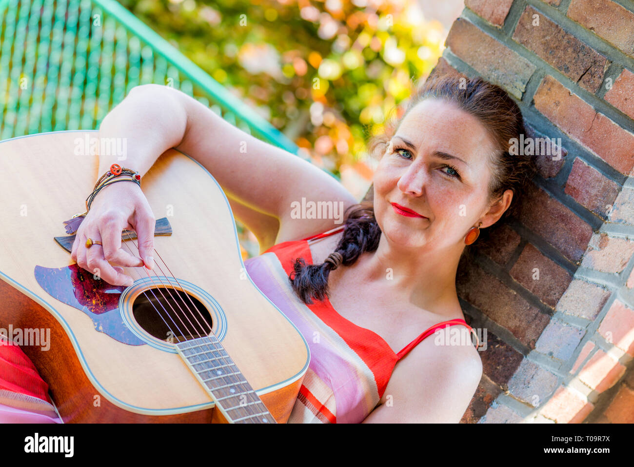 Belle femme d'âge moyen playing acoustic guitar Banque D'Images