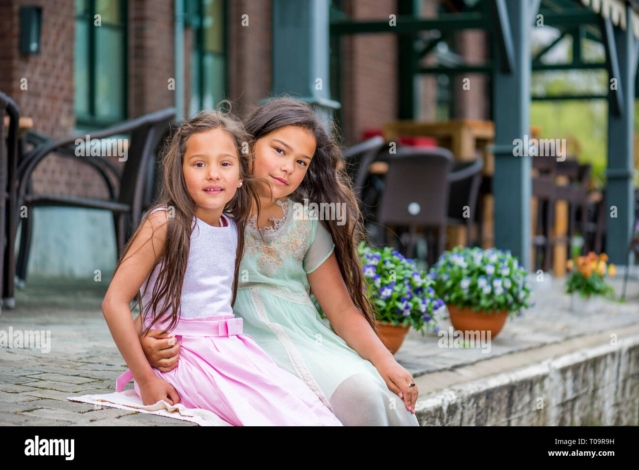 Deux belles sœurs asiatiques assis sur le trottoir Banque D'Images