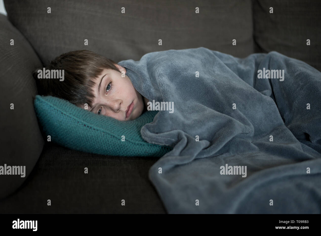 Petit garçon malade allongé sur le canapé Banque D'Images