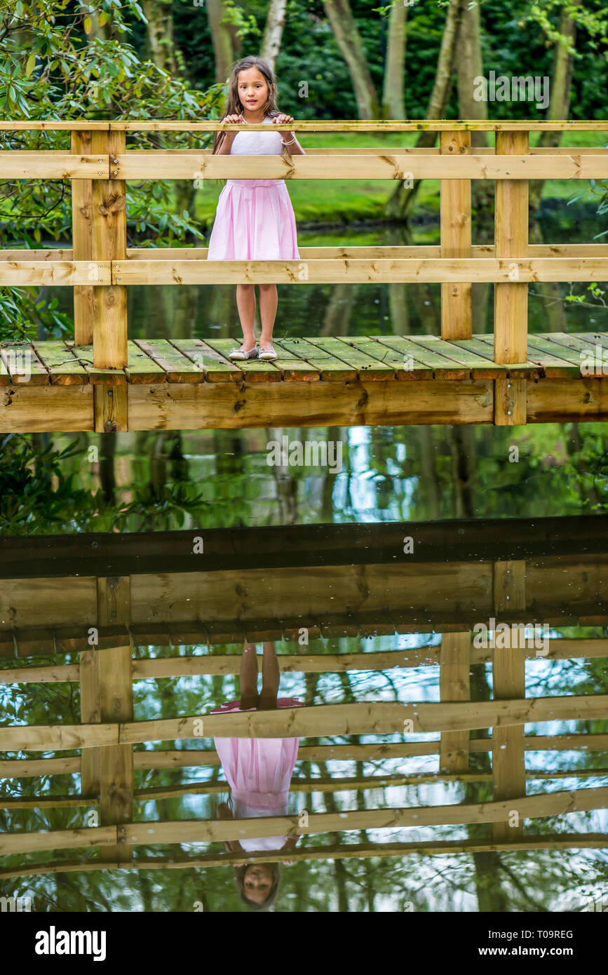 Petite fille thaïe sur un pont avec la réflexion ci-dessous Banque D'Images