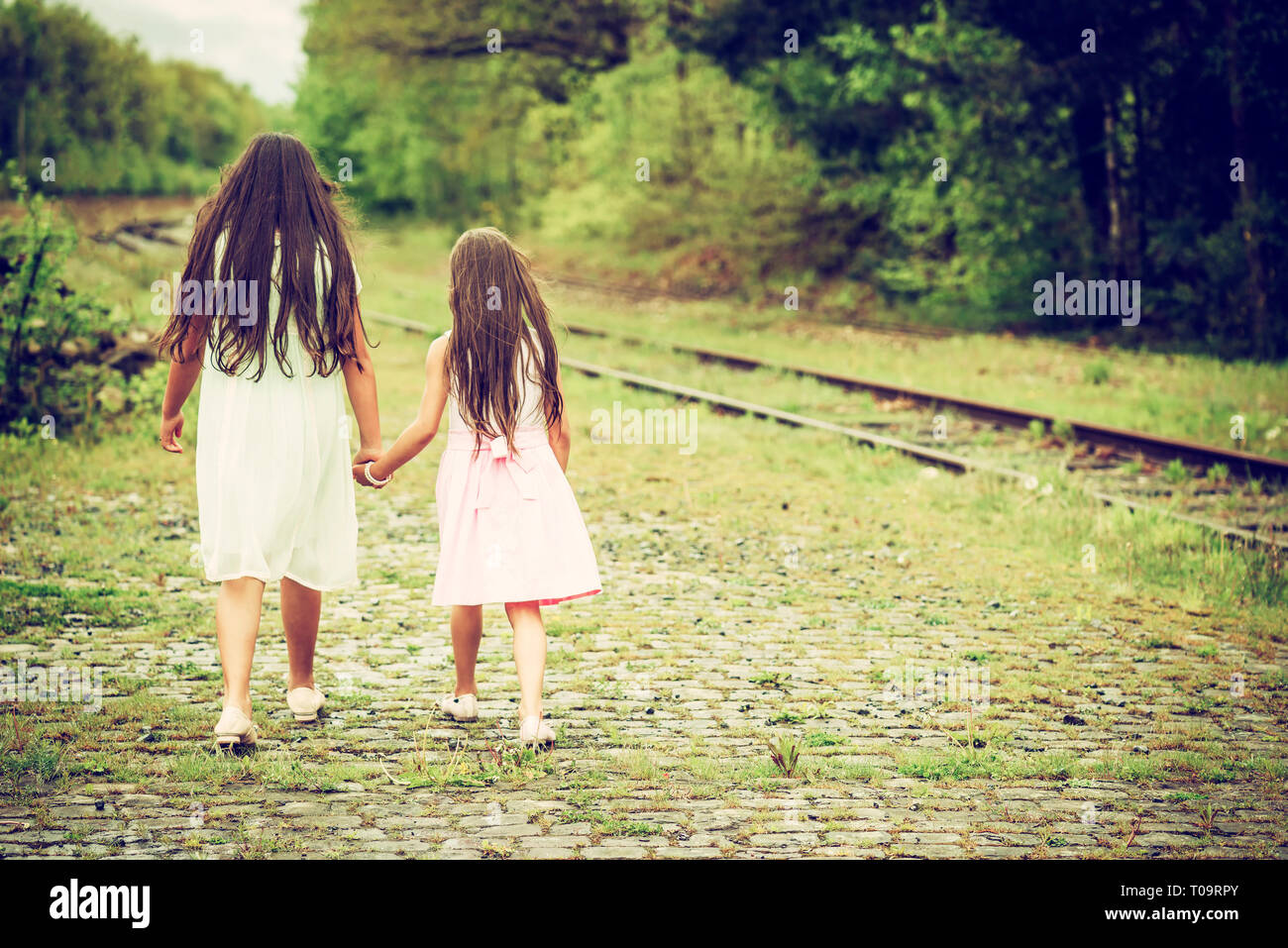 Deux sœurs marche à côté de la voie de chemin de fer, tourné par derrière Banque D'Images