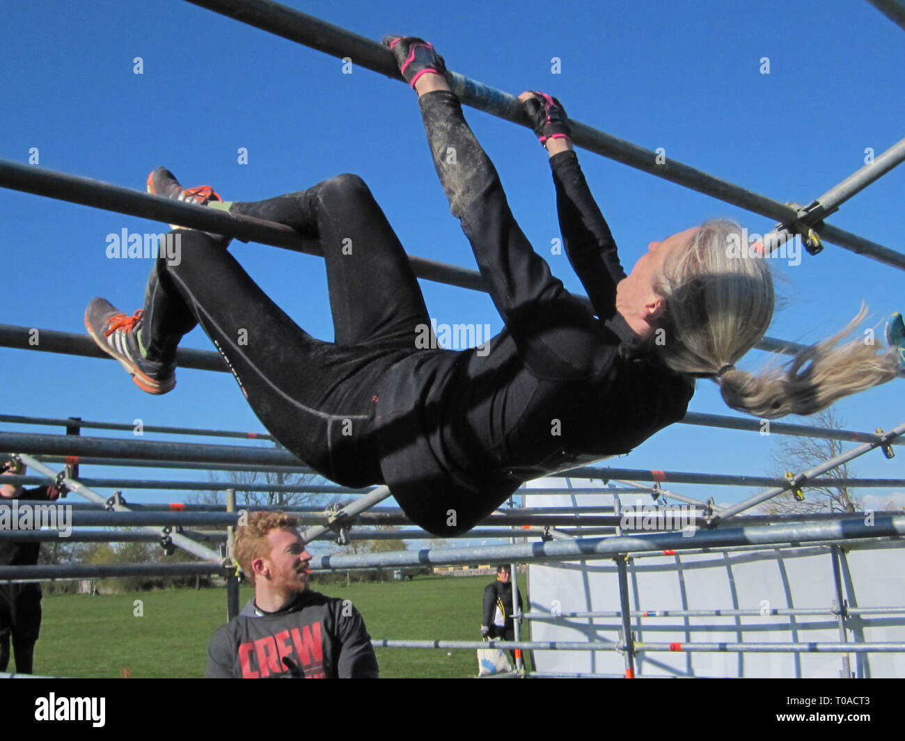 Les personnes actives au cours de l'extrême course à obstacles dans boot camp. Banque D'Images