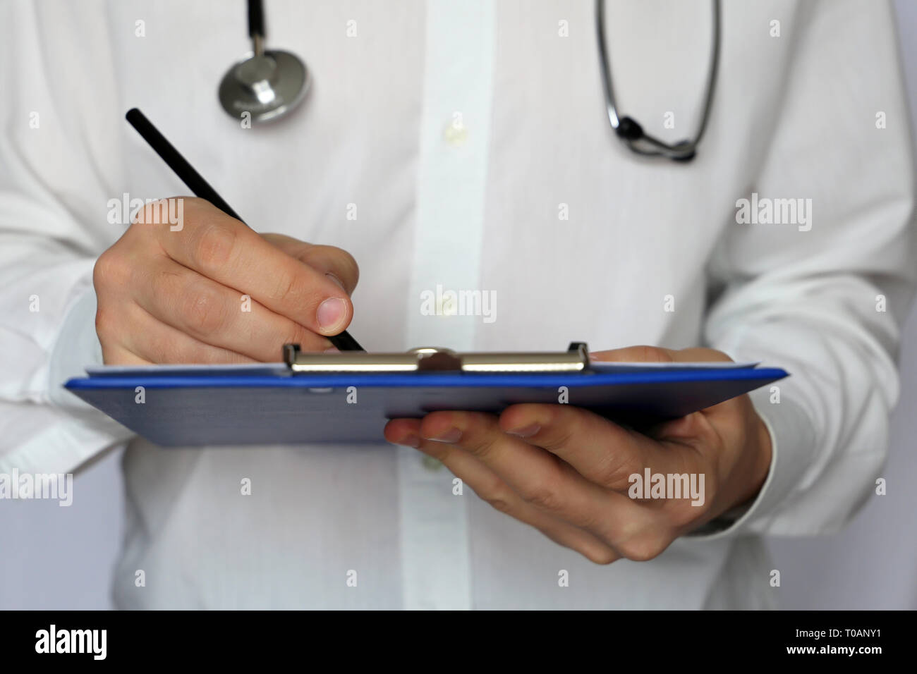 Doctor with stethoscope rédige une ordonnance papier, examen médical. Concept de la médecine, le diagnostic, le thérapeute, l'examen à la clinique, les soins de santé Banque D'Images