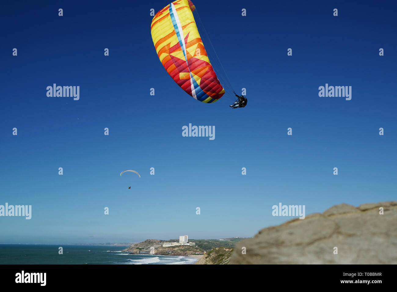 Un parapentiste effectuant un wingover à Santa Rita beach, Portugal Banque D'Images