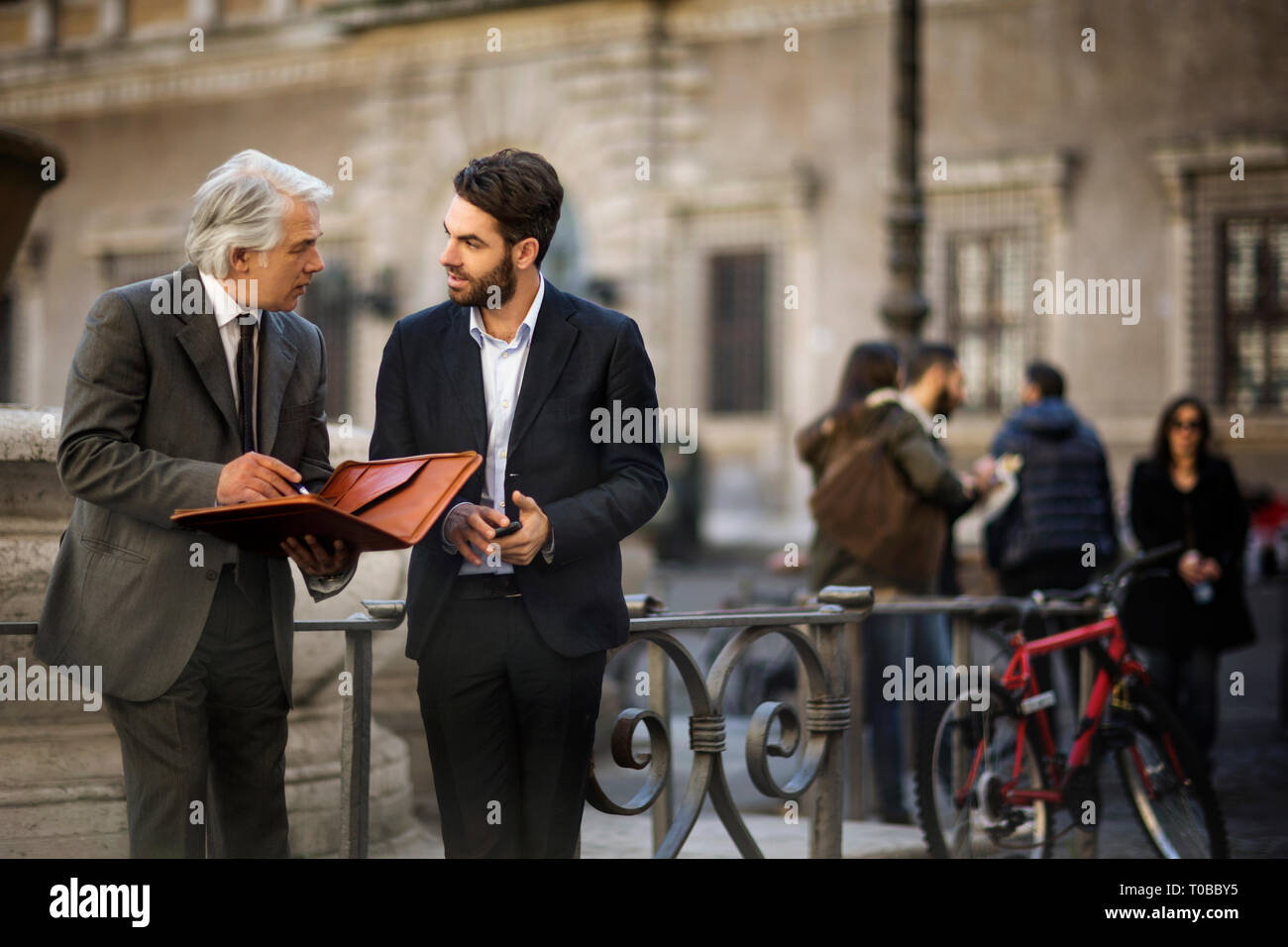 Mature businessman a une rencontre fortuite avec un jeune collègue, alors qu'ils sont dans la ville. Banque D'Images