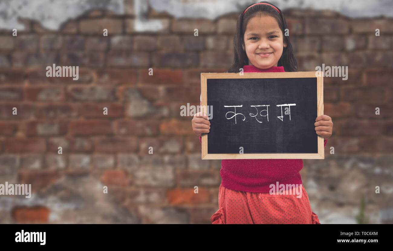 Adorable petit 8-10 ans Filles asiatiques indien souriant, tenant l'éducation tableau. Banque D'Images