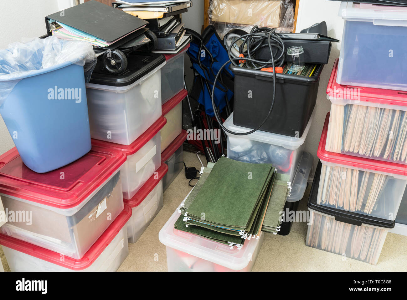Bureau malpropre avec zone de stockage de boîtes, classeurs, dossiers et fournitures diverses. Banque D'Images