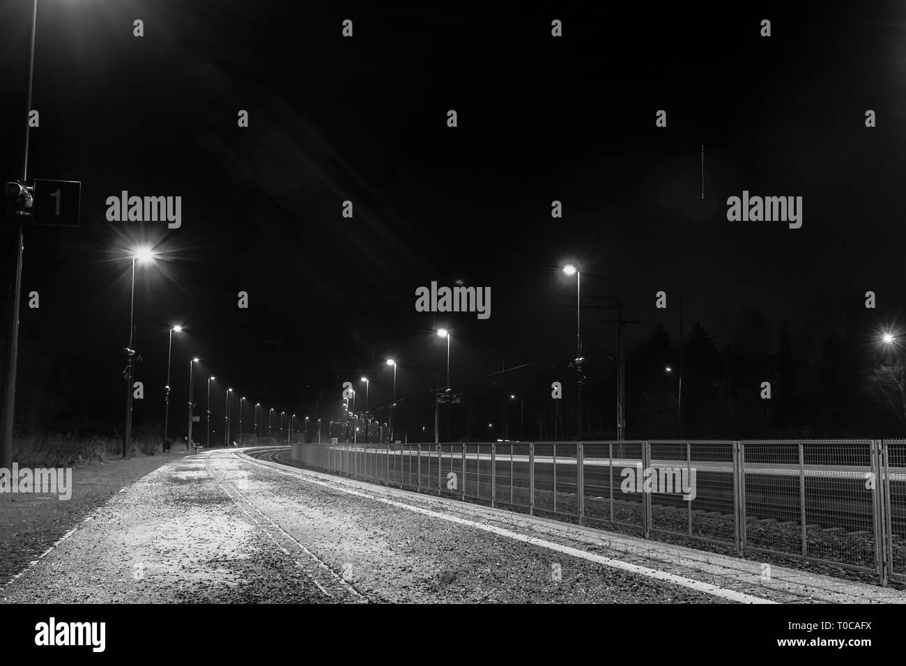 Une plate-forme vide lors d'une seule gare dans le Nord de la Finlande sur une nuit d'hiver. L'endroit est vide mais bien éclairée. Banque D'Images