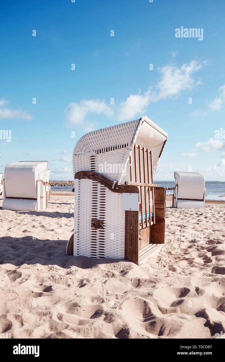 Chaises de plage en osier vide sur une plage de sable, harmonisation des couleurs appliquées. Banque D'Images