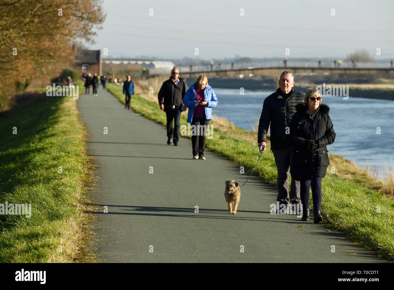 Les piétons et les promeneurs de chiens sur le chemin le long de la rivière Dee à Ferry Lane a la sortie de Chester vers le nord du Pays de Galles UK Banque D'Images