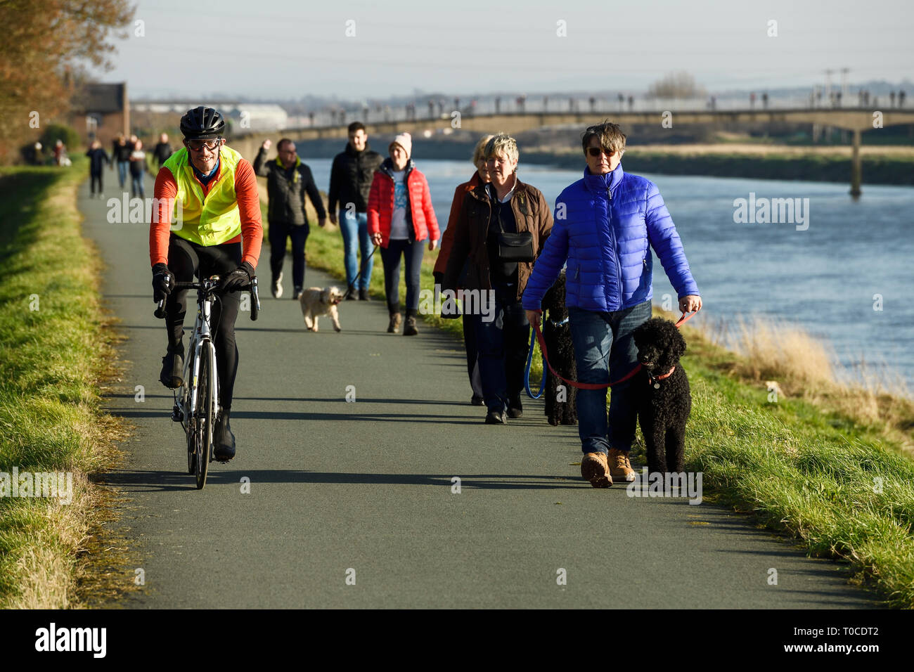 Cyclistes, piétons et promeneurs de chiens sur le chemin le long de la rivière Dee à Ferry Lane a la sortie de Chester vers le nord du Pays de Galles UK Banque D'Images
